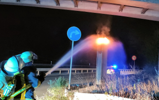 Feuerwehrleute löschen eine brennende Radarfalle